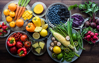 Obst und Gemüse in vielen verschiedenen Farben liegen auf diversen Tellern.