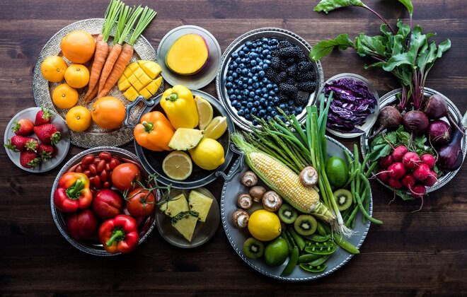 Obst und Gemüse in vielen verschiedenen Farben liegen auf diversen Tellern.