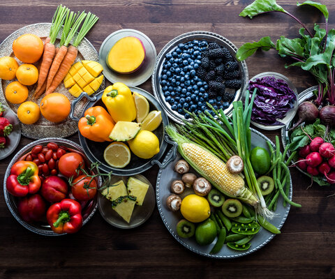 Obst und Gemüse in vielen verschiedenen Farben liegen auf diversen Tellern.