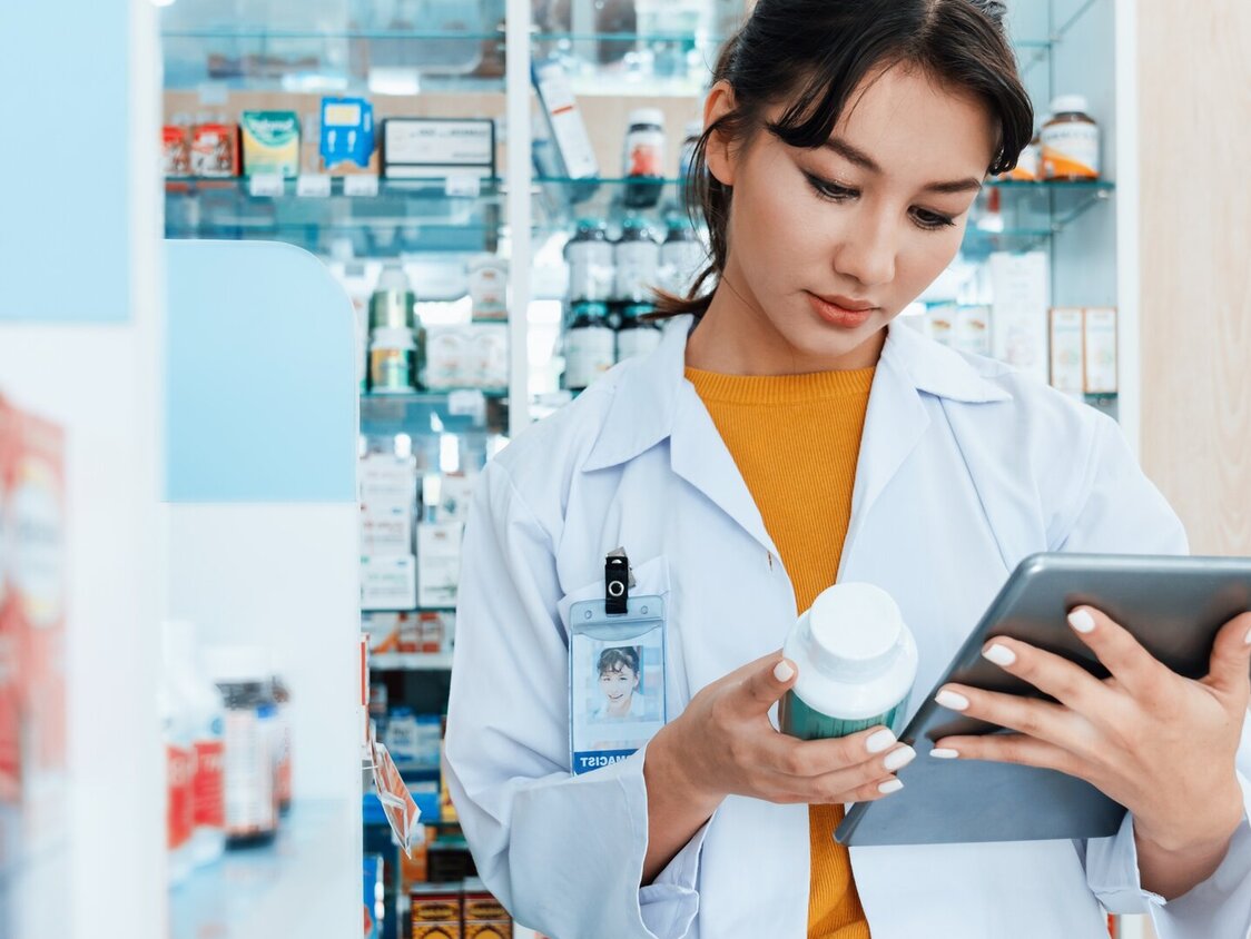 Eine Apothekerin schaut auf ein Tablet.